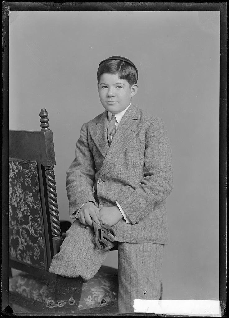 Portrait of a boy, Will Pruett, leaning on a carved chair, photographed by C. M. Bell.