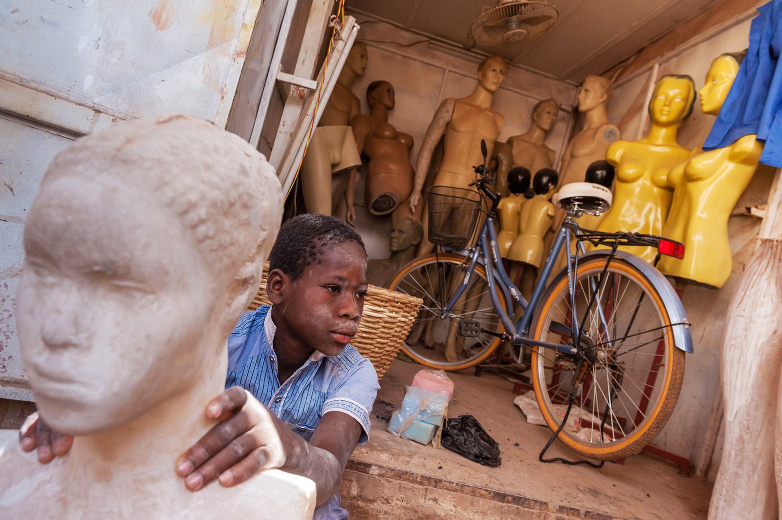 Boy fabricating shop mannequins, Ouagadougou, Burkina Faso.