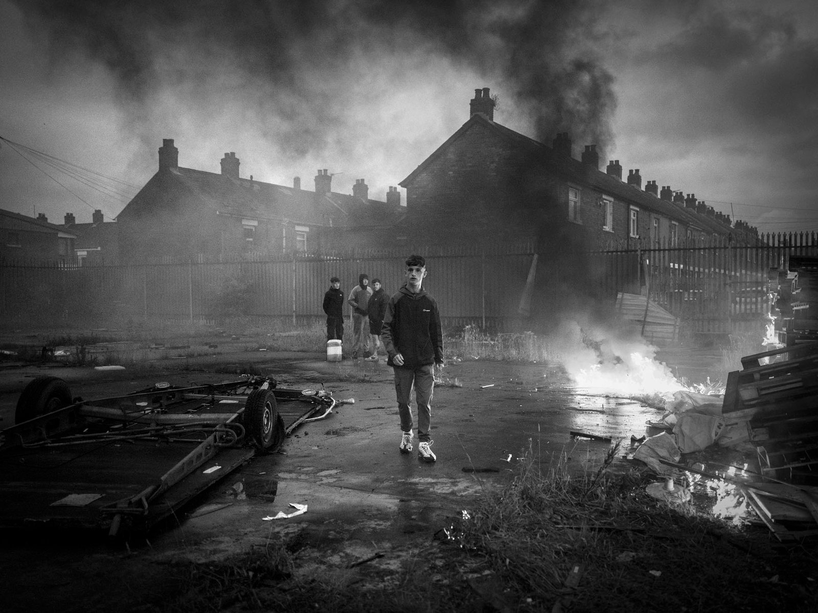 Leo walking past fire on wasteland at Roden Street, Belfast, July 2024.