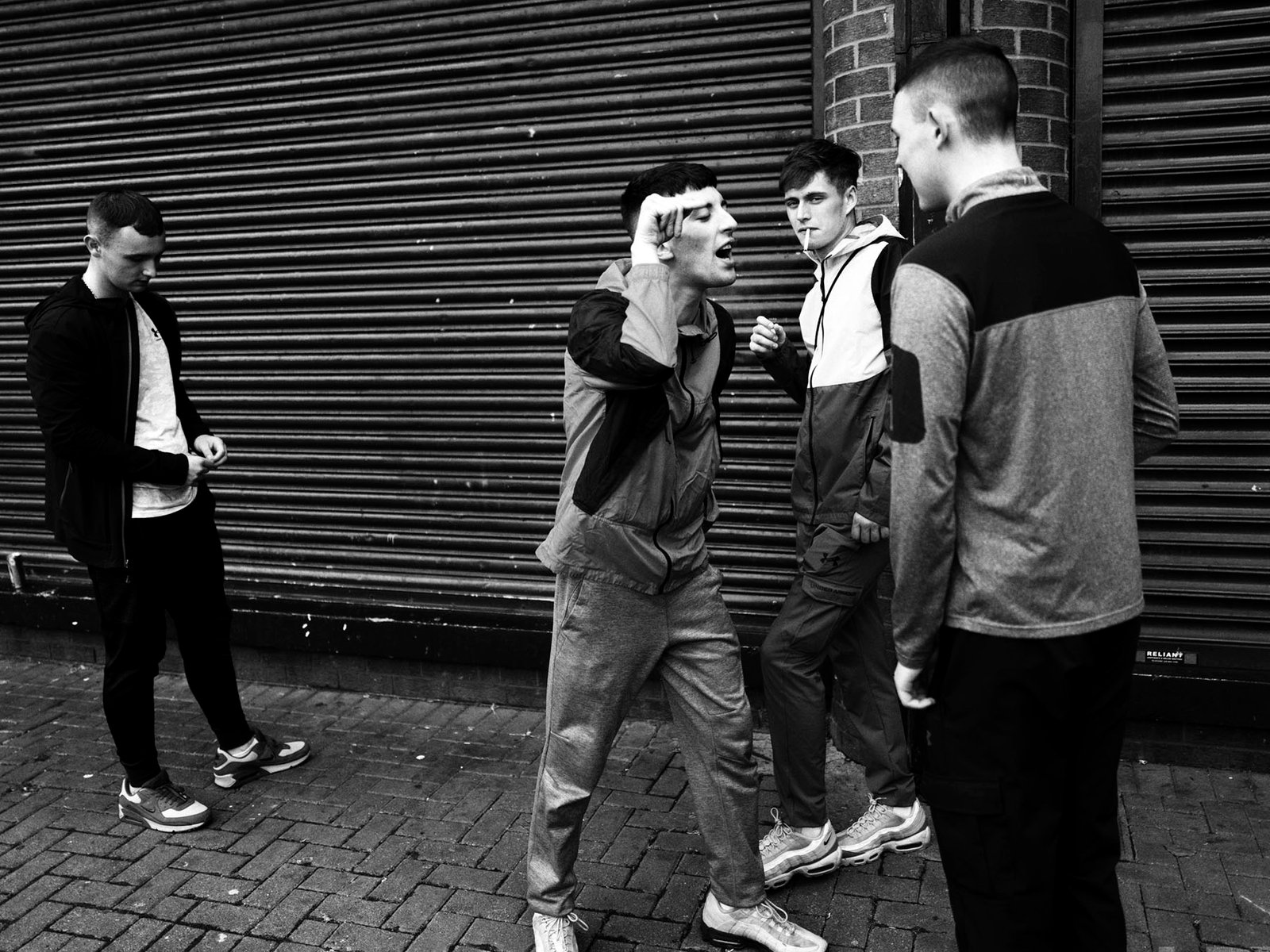 Michael and Sean arguing while David and Joe are smoking cigarettes, Belfast, July 2023.