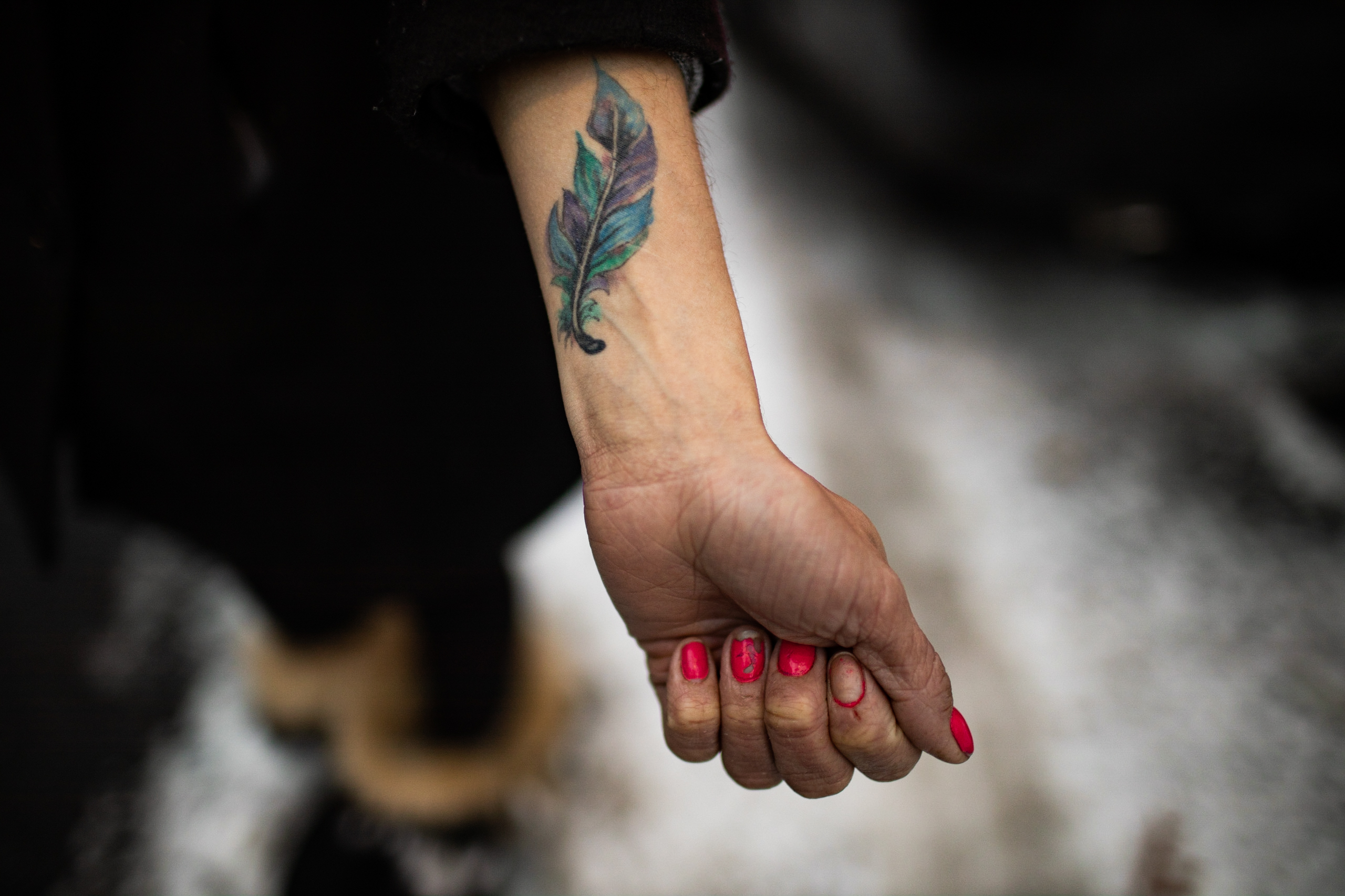 Cary's wrist with feather tattoo
